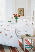 weiße Bettwäsche bestickt mit Rosen- blüten