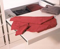 Ausziehbarer Funktionsboden für den Kleiderschrank mit 2 Pullovern