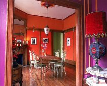 Eßzimmer eingerichtet mit Antiquitäten-Mix, rote Wände