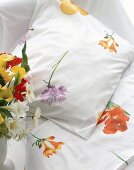 weiße Bettwäsche mit verschiedenen Blüten.