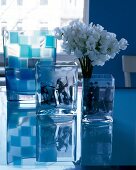 Table of three square glass vases with white flowers