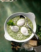 Three poached eggs with spinach sauce and parmesan cheese in serving bowl