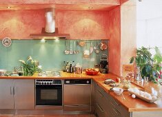 Küchenmöbel mit Edelstahlblechen verkleidet, farbige Wände