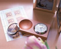 Uhr und Lupe in einem Buchenholzhalter mit runden Aussparungen