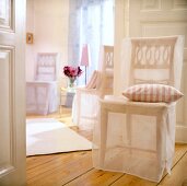 Wooden chair with transparent slipcover and cushion on wooden floor