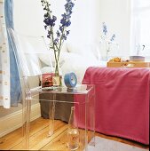 Neben dem Doppelbett dient der klare Kunststoffstuhl als Nachttisch