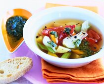 Minestrone soup with pesto in white bowl