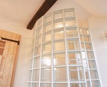 Duschbereich mit einer Wand aus Glasbausteinen in Schneckenform
