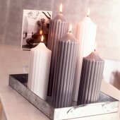 weiße und graue Kerzen in verschied- enen Größen,auf Metall-Tablett