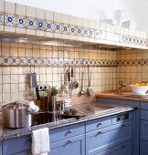 View of tiled kitchen wall with basin and stainless steel appliances