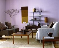 Braune Holztische und graue Sitzelem ente,violett gestrichene Wand