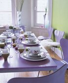 Dishes set with bird motif design in Asian look on purple dinning table