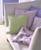 Pastellfarbene Kissen auf weißem Sofa