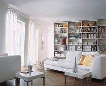lichtes Wohnzimmer,weißes Liegesofa, modernes Bücherregal,weiße Vorhänge