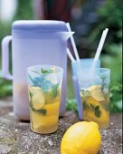 Zitronen-Minz-Tee in Plastikbechern und einer Plastikkanne