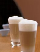 Zwei Gläser  Milchkaffee mit hohem Milchschaum