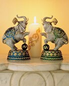 2 Buchstützen in Elefantenform stehen Spalier vor einer Kerze