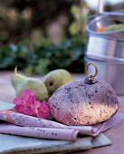 Stein mit Bronzegriff zum Beschweren der Zeitung bei Wind im Garten