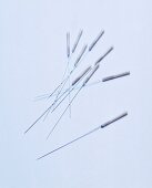 Variety of acupuncture needles on white background