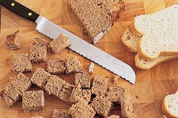 Brot wird für ein Käsefondue mit einem Brotmesser geschnitten. Nr.2
