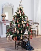 Christmas tree decorated with lanterns on table