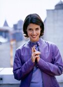 Portrait of pretty woman with short dark hair wearing purple leather jacket, smiling
