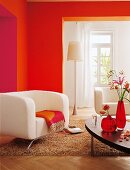 Sofa beige, Wand orange rot, Teppich Stehlampe, Blumenvasen, Couchtisch