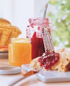 Gläser mit Marmelade und Gelee auf Frühstückstisch