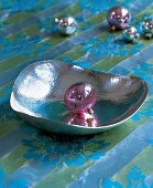 Silberschale aus Edelmetall mit einer lilanen Weihnachtskugel