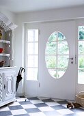 White front door with oval window in bright hall
