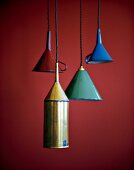 Funnel shaped pendant lights hanging against red background