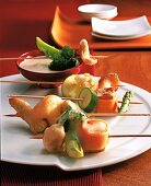 Vegetables, mushrooms and tofu in batter stuck on skewers for preparing tempura