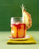 Pineapple and grenadine drink garnished with pineapple in glass