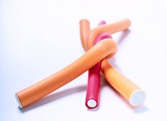 Red and orange curlers on white background