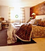 View of bedroom with brown floral bed sheet, blankets and pillows