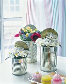 Empty tins filled with daisies, narcissi and hyacinths