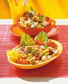 Pasta with arugula and feta in bowl and bean salad with corn and tuna on serving dish