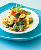 Close-up of farfalle pasta with tomato and zucchini on plate