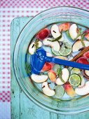 Ingredients for peach liqueur in glass bowl, overhead view