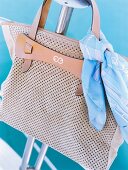 Close-up of brown leather handbag with blue scarf