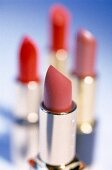 Close-up of open red lipsticks in various shades on table