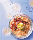 Carpaccio with salad and mashed egg on serving dish