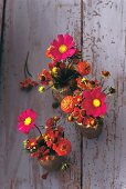 Three bouquets of summer flowers in vases, overhead view