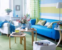 Living room with blue sofa, green carpet, cushion and wooden table
