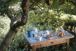 Rustikaler Kaffeetisch im Garten unter Bäumen