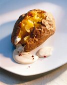 Close-up of baked potato with cream on plate