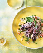 Rice with squid on yellow plate with squeezed lemon on table