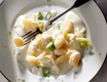Close-up of gnocchi with vegetables and fork on plate
