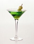 Green lady cocktail with woodruff taste in martini glass on white background