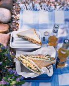 Egg and ham sandwich served with beer at picnic